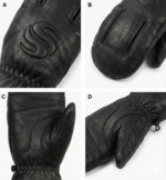 Black leather winter mittens with reinforced palm grip and pine background